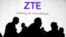 FILE - Visitors pass in front of the Chinese telecoms equipment group ZTE Corp booth at the Mobile World Congress in Barcelona, Spain, Feb. 26, 2018.