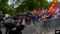 Turski policajac koristi pušku protiv nereda da rastjera članove Sindikata dok marširaju tokom proslave Praznika rada u Istanbulu, Turska, u srijedu, 1. maja 2024.