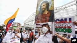 A man holds an image of Jesus during a silent march to support the unblocking of the city's main entrance and exit roads that have been blocked by anti-government protests in Cali, Colombia, Tuesday, May 25, 2021. Colombians have taken to the…