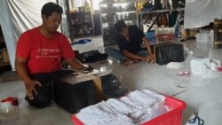 Relawan "Jatim for Indonesia" mengemas sejumlah bantuan untuk warga terdmpak corona di berbagai daerah (VOA/Petrus Riski).