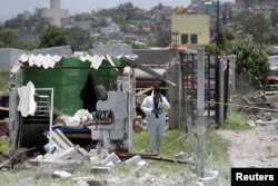 A forensic technician inspects a site damaged by fireworks explosions in the municipality of Tultepec, on the outskirts of Mexico City, Mexico, July 5, 2018.