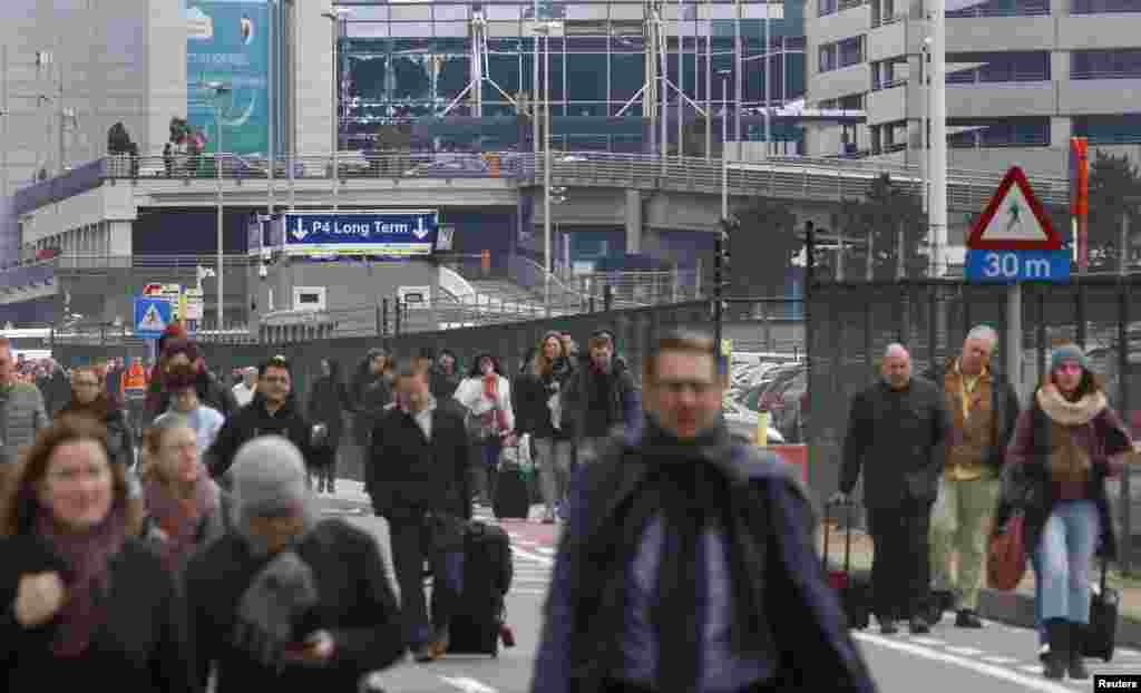 People leave the scene of explosions at Zaventem airport near Brussels, Belgium, March 22, 2016. 