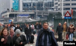 People leave the scene of explosions at Zaventem airport near Brussels, Belgium, March 22, 2016.