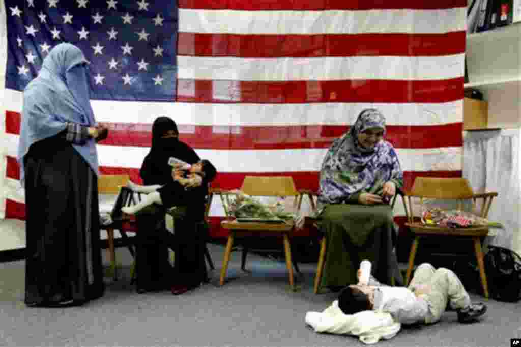 This citizen journalism image provided by AMC shows people on the top of houses that were damaged by an airstrike, Aleppo, Syria, April 15, 2013.