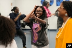 Hillary Amofa, laughs as she participates in a team building game with members of the Lincoln Park High School step team after school Friday, March 8, 2024, in Chicago. (AP Photo/Charles Rex Arbogast)