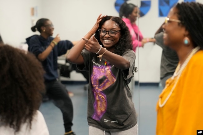 Hillary Amofa, laughs as she participates in a team building game with members of the Lincoln Park High School step team after school Friday, March 8, 2024, in Chicago. (AP Photo/Charles Rex Arbogast)