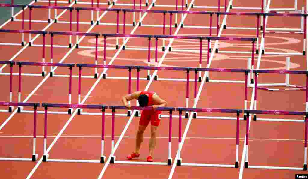 Liu Xiang dari Cina mencium gawang terakhir pada lintasannya setelah gagal menyelesaikan putaran lari gawang 110 meter putra karena cedera yang juga terjadi pada Olimpiade Beijing. (Foto: Reuters)