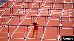 Lưu Tường hôn hàng rào trước khi phải rút khỏi cuộc tranh tài ở Olympic London 2012 vì chấn thương gân gót chân.