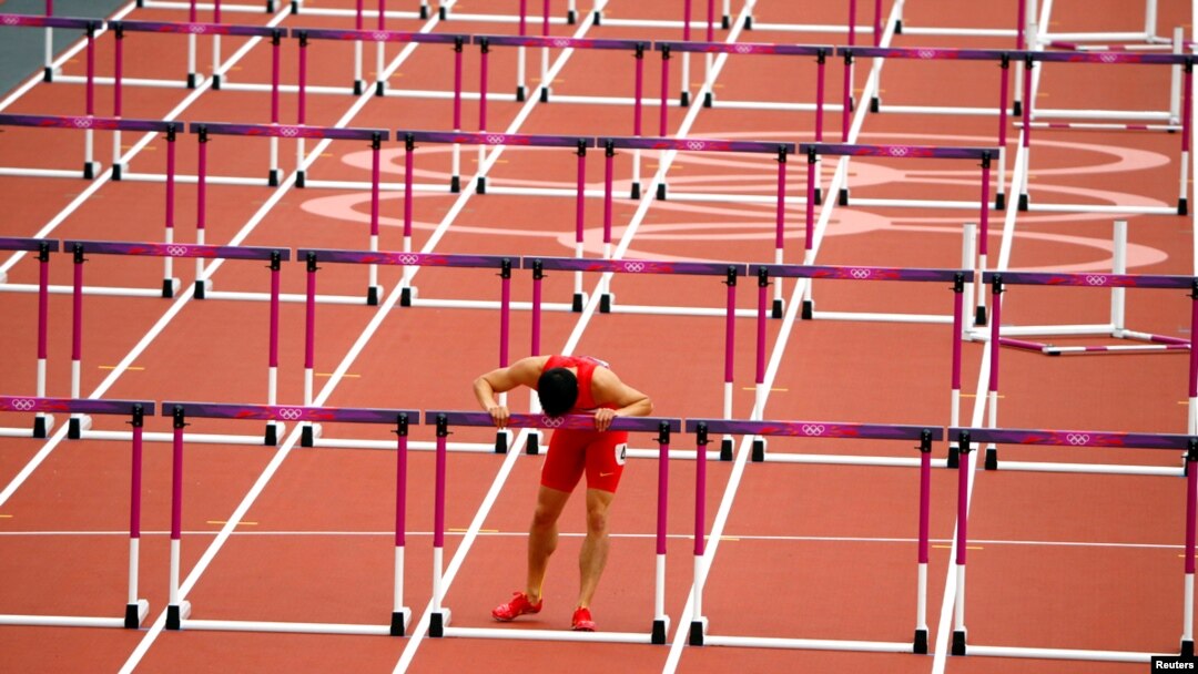 China's Liu Xiang leans against the last hurdle after crashing out of the heats in the 110 meter hurdles at the 2012 London Olympics. REUTERS/David Gray 