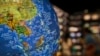 In this July 13, 2018, photo, people read books near a globe showing the southeast countries on the South China Sea with nine-dash line claims under Chinese territory on display at a bookstore in Beijing. 