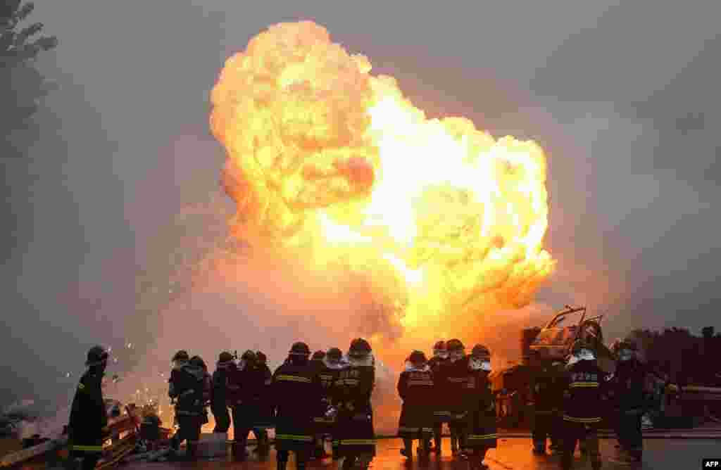 Firefighters work to put out a fire as white phosphorus exploded after a violent collision when a truck crashed into another vehicle on a highway in Wuhan, central China&#39;s Hubei province. One of the two truck drivers was killed in the accident while the other succeeded to get out of the truck before the explosion.