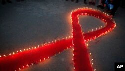 Nepalese women and children from "Maiti Nepal," a rehabilitation center for victims of sex trafficking, light candles on the eve of World AIDS Day in Kathmandu, Nepal, Nov. 30, 2016. World AIDS Day is observed December 1 every year to raise the awareness in the fight against HIV. 