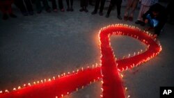 Perempuan dan anak-anak Nepal dari "Maiti Nepal", pusat rehabilitasi untuk korban perdagangan seks, menyalakan lilin pada malam Hari AIDS Sedunia di Kathmandu (30/11). (AP/Niranjan Shrestha)