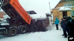 Yelena Salnikova, in a blue jacket, a nurse from a small town of Berezovskiy, Russia, gets a truck full of coal from authorities in the Kemerovo coal-rich region for losing 30 kilos (66 pounds) in weight, Dec. 23, 2015. 