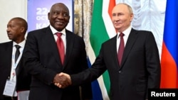 Presiden Afrika Selatan Cyril Ramaphosa berjabat tangan dengan Presiden Rusia Vladimir Putin saat hadiri KTT BRICS di Kazan, Rusia (22/10). 