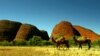 Two feral camels stand in front of a group of rock monoliths known as The Olgas, south west of the central Australian town of Alice Springs. The Olgas are known by local Aboriginals as Kata Tjuta are considered sacred sites by their Aboriginal owners.