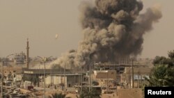 FILE - Smoke rises after an airstrike during fighting between members of the Syrian Democratic Forces and Islamic State militants in Raqqa, Syria, Aug. 15, 2017.