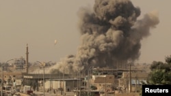 FILE - Smoke rises after an airstrike during fighting between members of the Syrian Democratic Forces and Islamic State militants in Raqqa, Syria, Aug. 15, 2017.