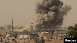 FILE - Smoke rises after an airstrike during fighting between members of the Syrian Democratic Forces and Islamic State militants in Raqqa, Syria, Aug. 15, 2017.