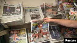 Seorang pria membeli koran sehari setelah Inggris memutuskan keluar dari Uni Eropa di sebuah kios surat kabar di pusat kota London, Inggris (25/6). 