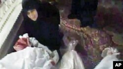 Image made from amateur video released December 27, 2011, purports to show a woman mourning over a relative who has been killed in Homs, Syria, December 26, 2011.