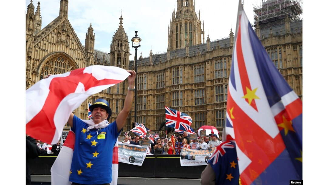 FILE - Pro- and anti-Brexit protesters demonstrate on opposite sides of the road outside the Houses of Parliament in London, September 5, 2018.