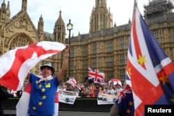 FILE - Pro- and anti-Brexit protesters demonstrate on opposite sides of the road outside the Houses of Parliament in London, September 5, 2018.