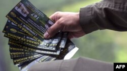 FILE - A Colombian anti-narcotics police officer holds pamphlets offering rewards for information leading to the capture of members of the Gulf Clan cartel, as part of the Agamemnon anti-drug trafficking operation in Apartado, Antioquia department, Colombia, May 31, 2017.