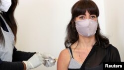 Robyn Porteous, volontaire des essais de vaccins, reçoit une injection d'un vaccin dans le cadre de l'essai clinique à Johannesburg, Afrique du Sud , 27 août 2020.
