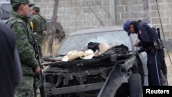 Soldiers and police inspect the site of an explosion in the village of Jesus Tepactepec, near the state capital Tlaxcala, Mar. 15, 2013.