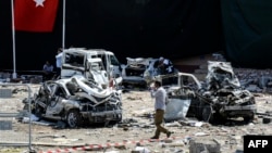 A man walks among the wreckage of vehicles as Turkish rescue workers and police inspect the blast scene following a car bomb attack on a police station in the eastern Turkish city of Elazig, Aug. 18, 2016. The explosion, blamed by Defense Minister Fikri Isik on the outlawed Kurdistan Workers' Party (PKK), happened in the garden of the four-storey building in Elazig.
