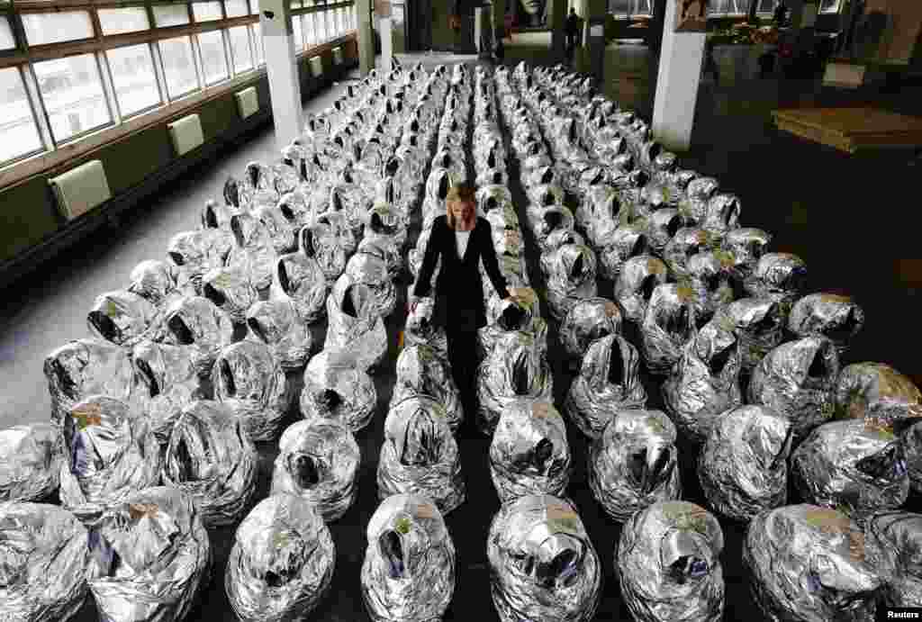 A Christie's worker poses with artist Kader Attia's artwork "Ghost", as part of "Thinking Big" auction on display in London.