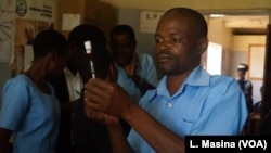 Un agent de la santé s'apprête à administrer un vaccin à un patient dans un hôpital communautaire à Lilongwe, au Malawi.