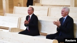 FILE - Russian President Vladimir Putin, left, and oligarch Gennady Timchenko visit a new concert hall of the Mariinsky Theater in St. Petersburg, Russia, June 3, 2017.