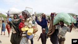A Somali family from southern Somalia, after traveling 500kms, arrive at a refugee camp in Mogadishu, Somalia, July 16, 2011
