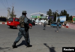 FILE - Afghan policemen stand guard outside of Kabul Airport after rockets exploded in Kabul, Afghanistan Sept. 27, 2017.