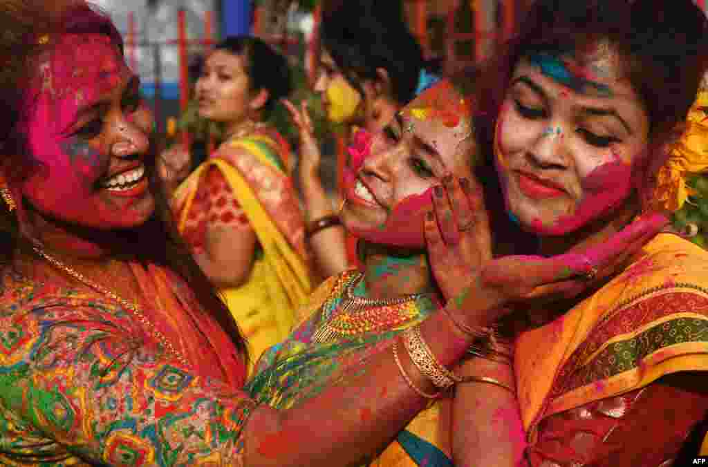 Para mahasiswi India mengusapkan bubuk berwarna ke wajah rekannya saat merayakan festival Hindu &quot;Holi&quot; di Kolkata.