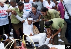 Hours before U.S. President Barack Obama arrives, policewomen drag away a member of Ladies in White, a women's dissident group that calls for the release of political prisoners, during their weekly protest in Havana, Cuba, March 20, 2016.