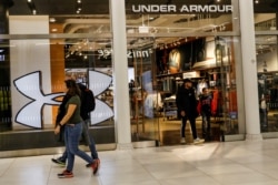 FILE PHOTO: Customers exit an Under Armour store in New York City, U.S., November 4, 2019.