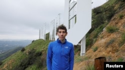 Climber Alex Honnold, from the Academy Award nominated documentary "Free Solo", poses for a picture next to the iconic sign in the Hollywood hills of Los Angeles, California, U.S., February 1, 2019. (REUTERS/Mike Blake)