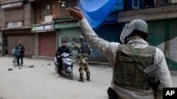 FILE - Indian paramilitary soldiers order commuters to turn back during a security lockdown in downtown Srinagar, Indian-controlled Kashmir, March 1, 2019.