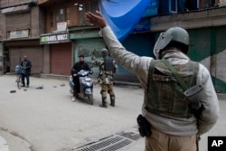 Indian paramilitary soldiers order commuters to turn back during a security lockdown in downtown Srinagar, Indian-controlled Kashmir, March 1, 2019.