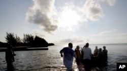 Grupa ljudi šalje u okean mali splav sa "ponudama za pretke" 19. juna 2005. na plaži Virdžinija Ki u Majamiju, koja je nekada bila označena kao plaža samo za crnce.