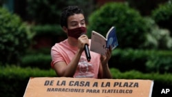 Percibald Garcia uses a microphone to read aloud children's stories amid the high-rise housing complex of Tlatelolco, in Mexico City, Saturday, July 18, 2020. 