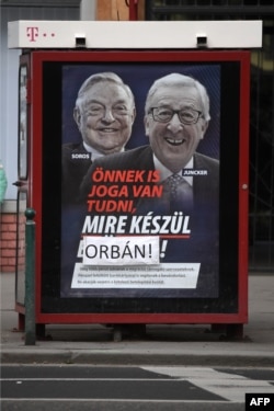 A poster on a telephone booth shows EC chief Jean-Claude Juncker, right, and Hungarian-born U.S. investor George Soros and a slogan reading "You too have a right to know what Brussels is preparing" as the name "Brussels" is covered by the family name of Hungarian Prime Minister Orban in Budapest on Feb. 26, 2019.