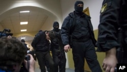 Police escort Zaur Dadaev, center, one of five suspects in the killing of Boris Nemtsov from a court room in Moscow, Russia, March 8, 2015. 