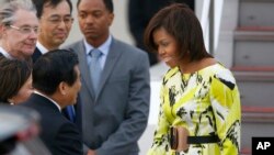 U.S. first lady Michelle Obama, right, is greeted by an unidentified Japanese official upon her arrival at Haneda International Airport in Tokyo, March 18, 2015. 