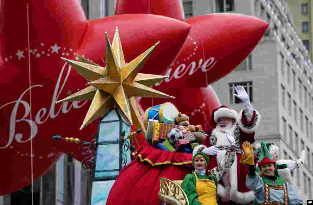 دست تکان دادن بابانوئل در مراسم رژه روز شکرگزاری در نیویورک، از جمله رژه فروشگاه زنجیره های میسیز که همه ساله هزاران نفر را به خیابان می کشاند.