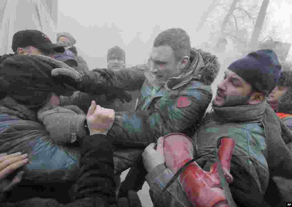 Opposition leader and former WBC heavyweight boxing champion Vitali Klitschko, center, is attacked and sprayed with a fire extinguisher as he tries to stop the clashes between police and protesters in central Kyiv, Ukraine.&nbsp;