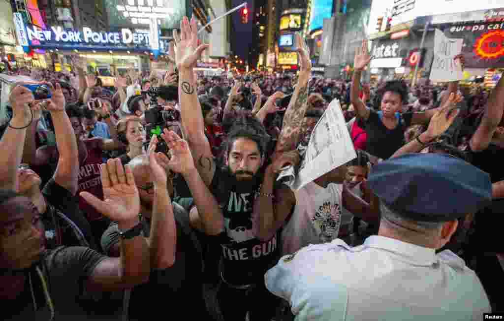 Protesters raise their hands during a peaceful demonstration, as communities react to the shooting of Michael Brown in New York&#39;s Times Square, Aug. 14, 2014.